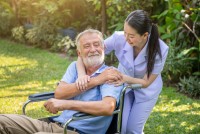 happy-nurse-holding-elderly-man-hand-wheelchair-garden-nursing-home.jpg