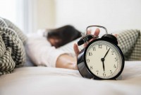sleepy-woman-reaching-holding-alarm-clock.jpg